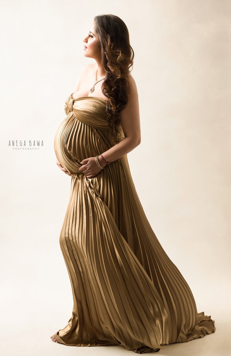 Maternity Photography in Delhi: Golden Pleated Gown, Beige Backdrop, by Anega Bawa, Photographer Gurgaon Noida.