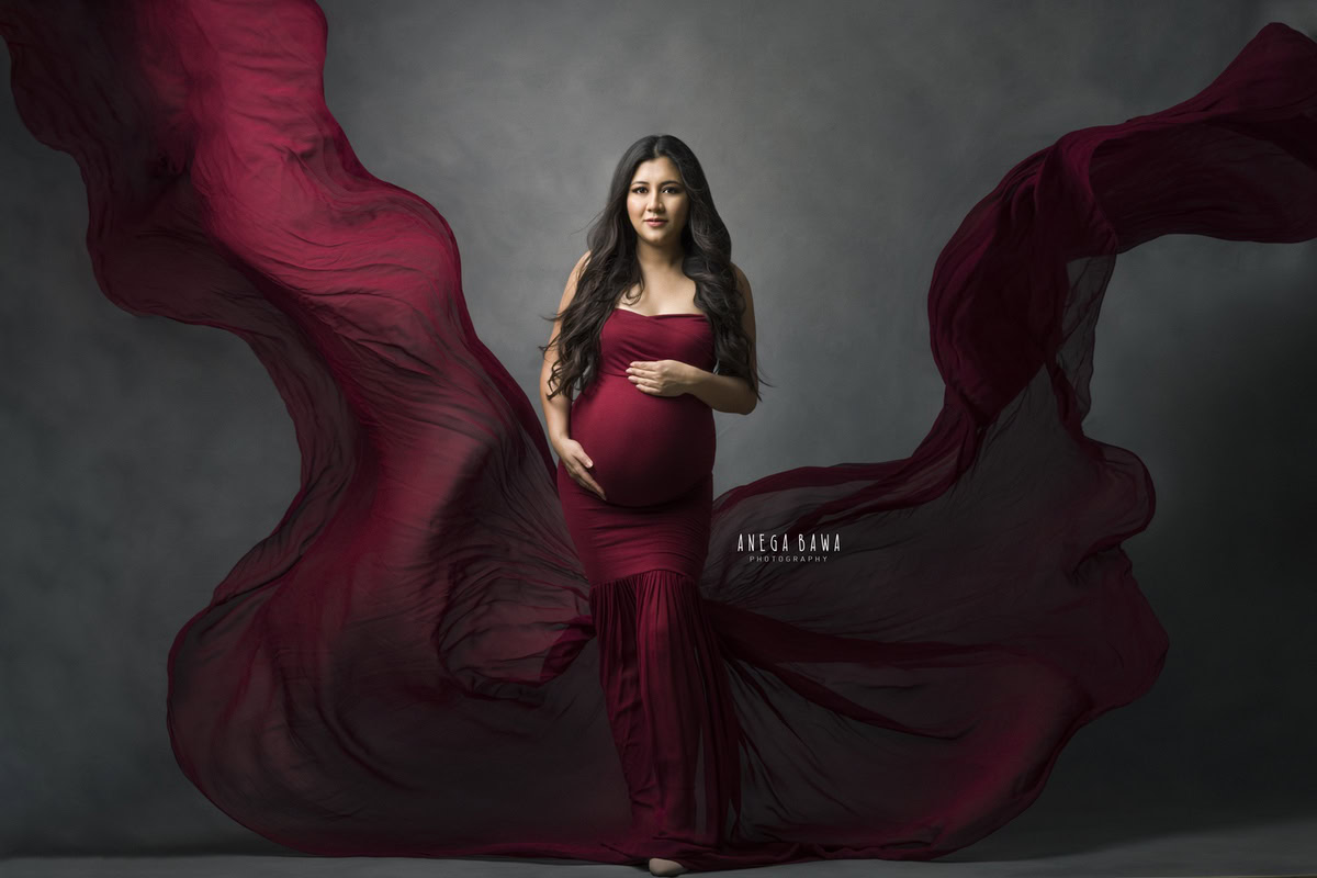 Maternity Photoshoot Delhi: Red Maroon Tube with Drape, Grey Backdrop by Anega Bawa Photography, Gurgaon Noida