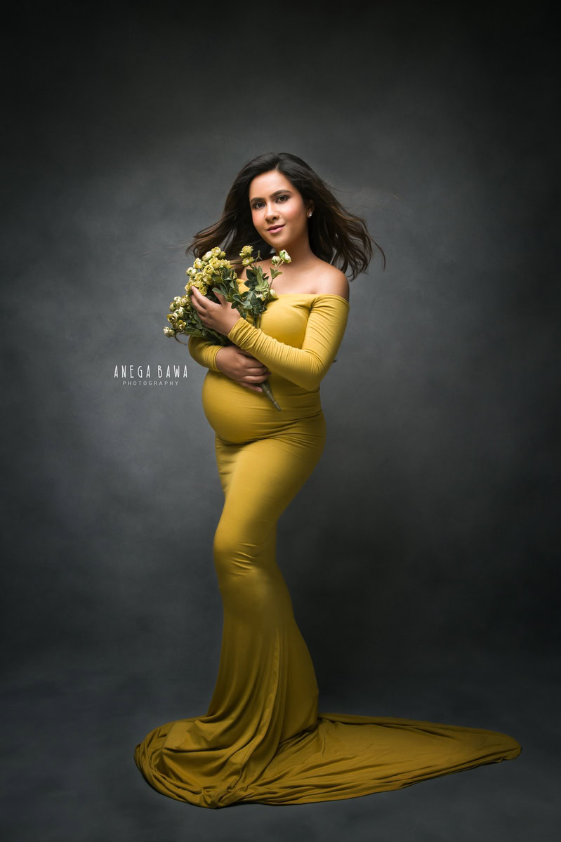Maternity Photoshoot in Delhi: Yellow Dress, Flowers in Hand, Dark Grey Backdrop, by Anega Bawa Photography, Gurgaon Noida.