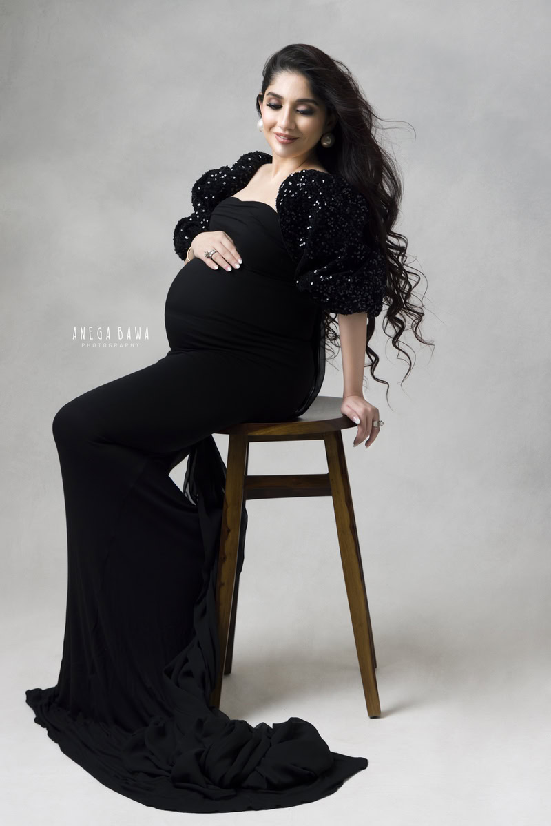 Maternity Shoot Delhi: Black Gown with Puffy Sleeves, Sitting, Grey Backdrop, by Anega Bawa Photography, Gurgaon Noida.
