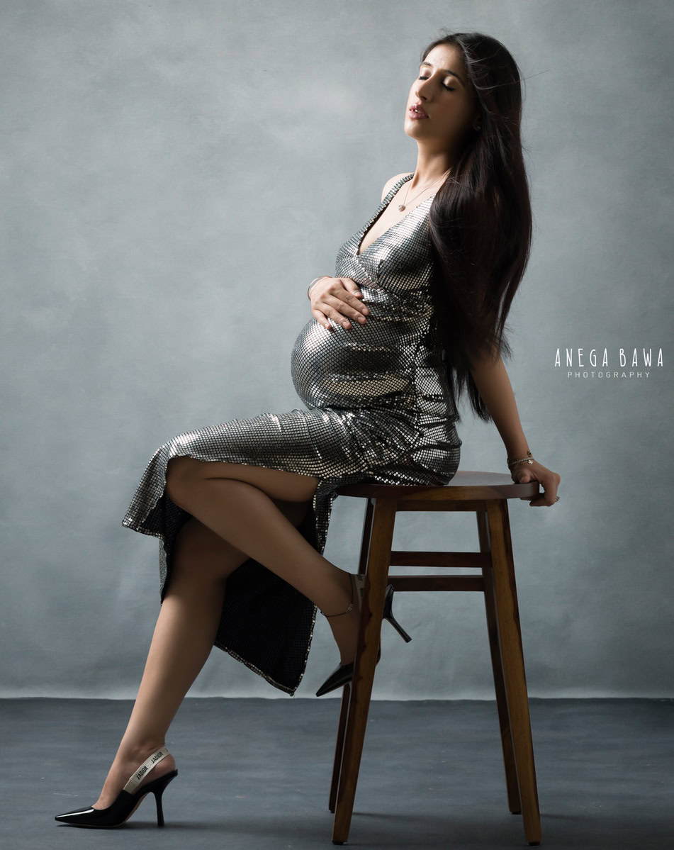 Pregnancy Photography in Delhi: Silver Dress, Sitting, Grey Backdrop by Anega Bawa Photography, Gurgaon Noida