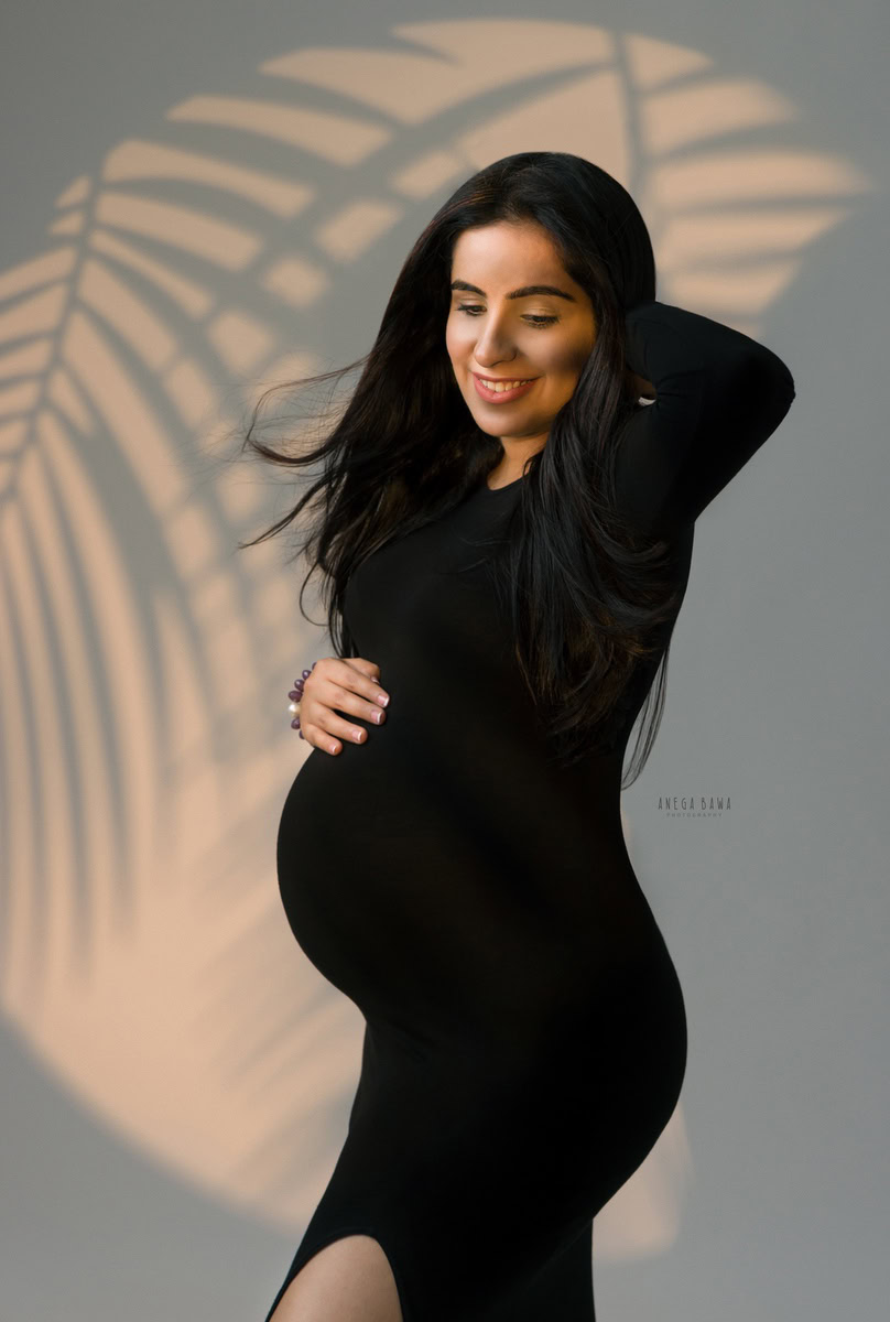 Pregnancy Photoshoot in Delhi: Black Slit Dress, Grey Backdrop, by Anega Bawa Photography, Gurgaon Noida.