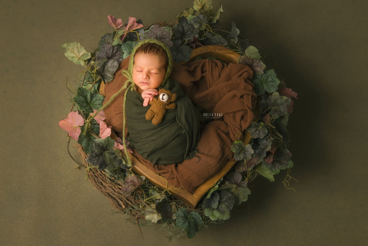 Gurgaon Newborn Photography: Green Wrap, Heart-shaped Basket, Soft Toy, Green Backdrop. Photographer: Anega Bawa, Delhi Noida.