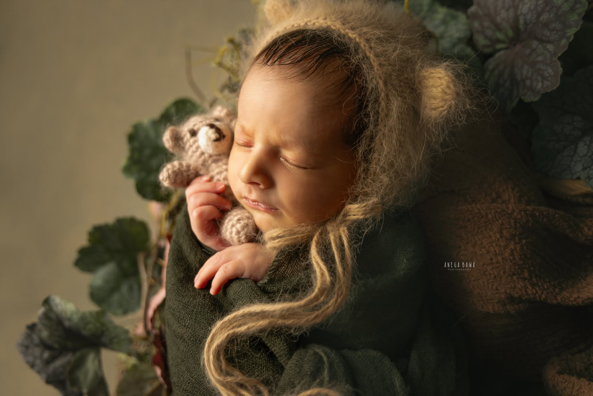 Newborn Photographer in Delhi: Green Wrap with Brown Cap and Soft Toy in Sleeping Pose, by Anega Bawa Photography, Gurgaon Noida.