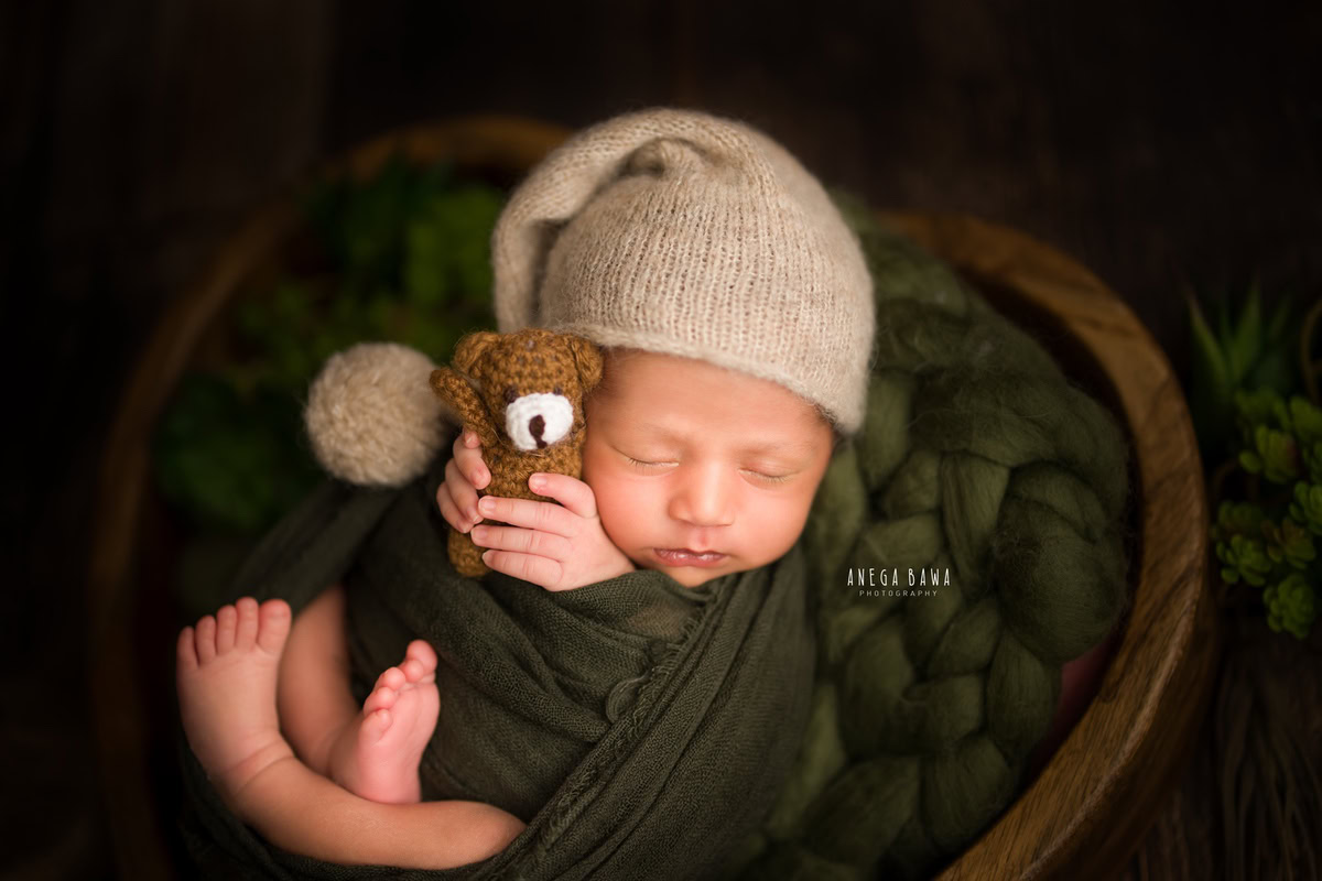 Newborn Photography in Delhi: Green Wrap with Soft Toy on Black Backdrop. Photographer: Anega Bawa Photography, Gurgaon Noida.