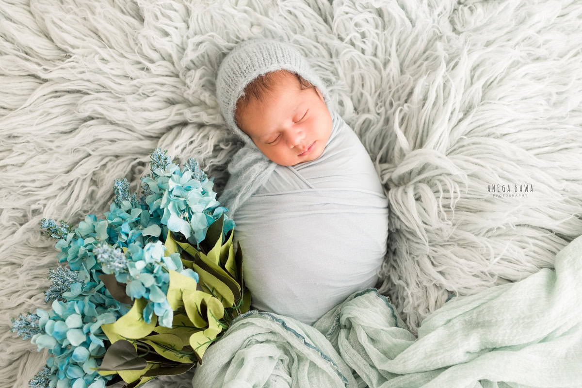 Newborn Photography in Delhi: Light Blue Rug with Blue Flowers. Photographer: Anega Bawa Photography, Gurgaon Noida.