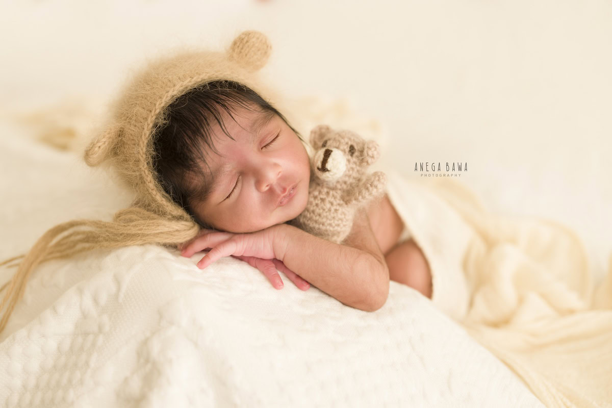 Newborn Photography in Delhi: Beige Cap, Soft Toy, White Sheet, White Backdrop, Anega Bawa Photographer, Gurgaon Noida.