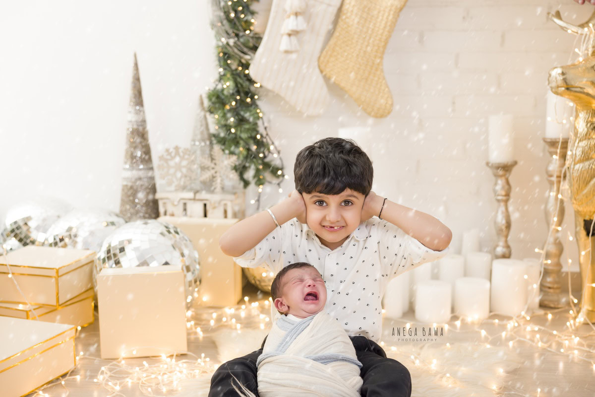 Newborn Photography in Delhi: Blue and White Wrap, Sibling, Christmas Gifts, Candles, White Backdrop, by Anega Bawa Photographer, Gurgaon Noida.