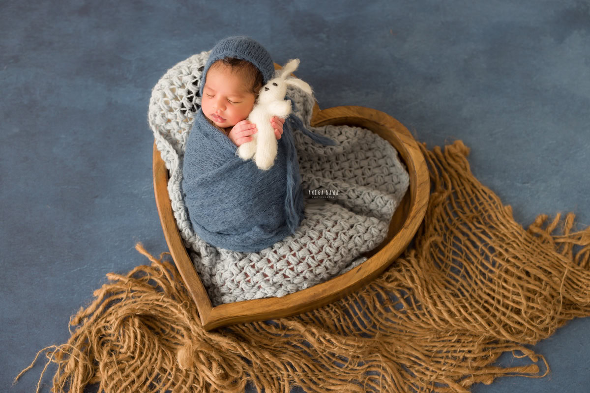 Newborn Photography in Delhi: Blue Wrap, Brown Rug, Blue Backdrop with Soft Toy. Photographer: Anega Bawa Photoshoot, Gurgaon Noida.