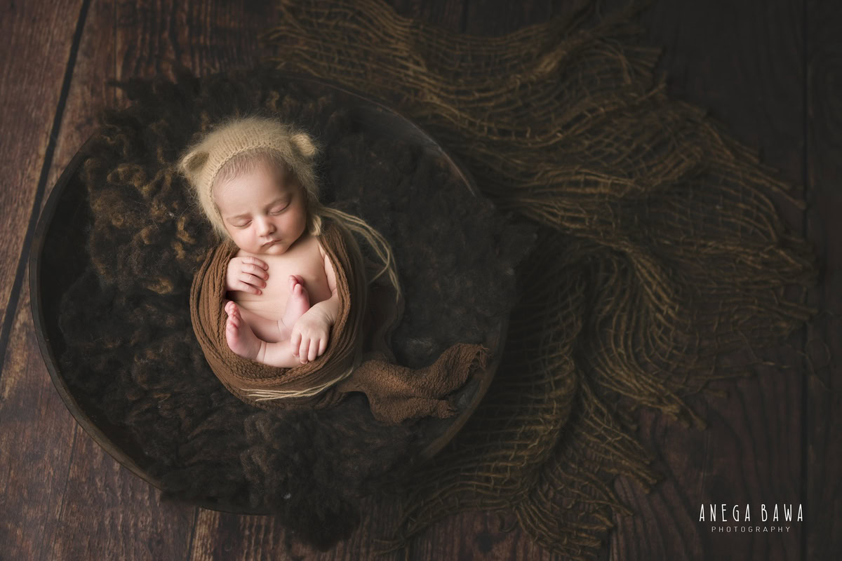 Newborn Photography in Delhi: Brown Rug, Brown Wrap, Beige Cap, Brown Backdrop. Photographer: Anega Bawa Photoshoot, Gurgaon Noida.