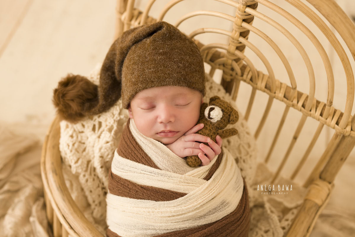 Newborn Photography in Delhi: Brown and White Wrap, Soft Toy, Brown Cap. Photographer: Anega Bawa Photoshoot, Gurgaon Noida.