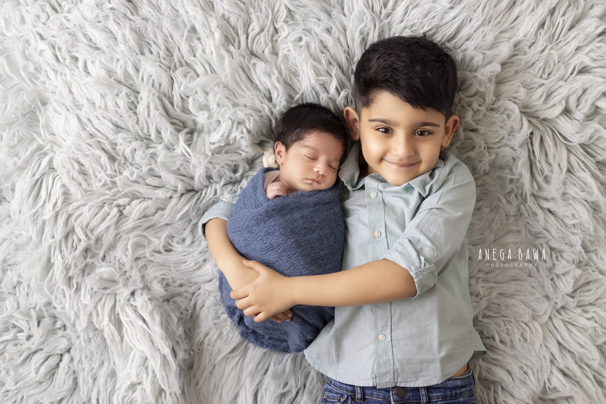 Newborn Photography in Delhi: Brown Wrap, Grey Rug, Lying on Floor. Photographer: Anega Bawa Photoshoot, Gurgaon Noida.