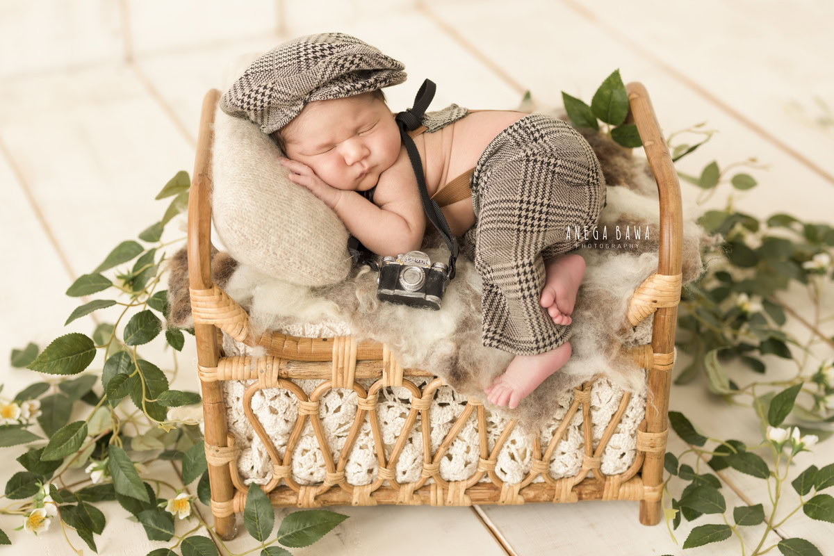Newborn Photography in Delhi: Burberry Cap, Wooden Cot, Leaves on Floor, White Backdrop, by Anega Bawa Photographer, Gurgaon Noida.