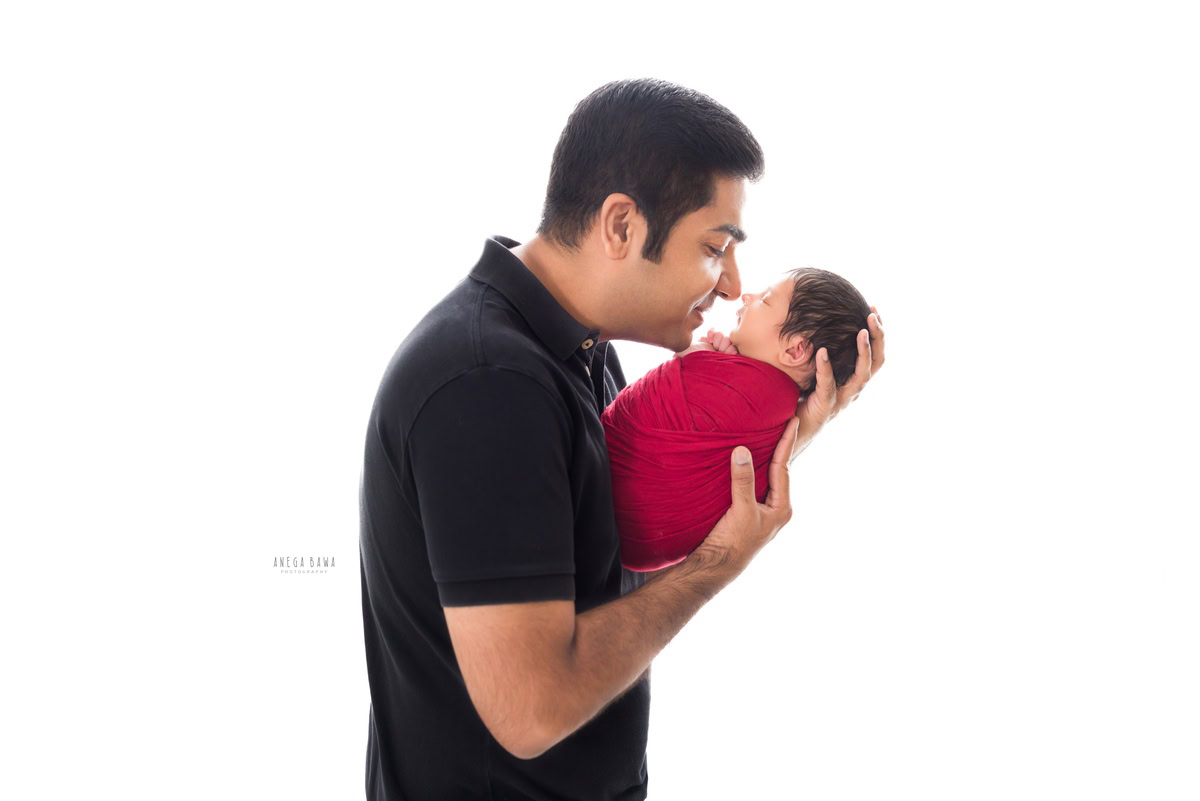 Newborn Photography in Delhi: Father holding newborn against a white backdrop. Photographer: Anega Bawa Photography, Gurgaon. Newborn Photography in Delhi: Father holding newborn against a white backdrop. Photographer: Anega Bawa Photography, Gurgaon. Newborn Photography in Delhi: Father holding newborn against a white backdrop. Photographer: Anega Bawa Photography, Gurgaon.