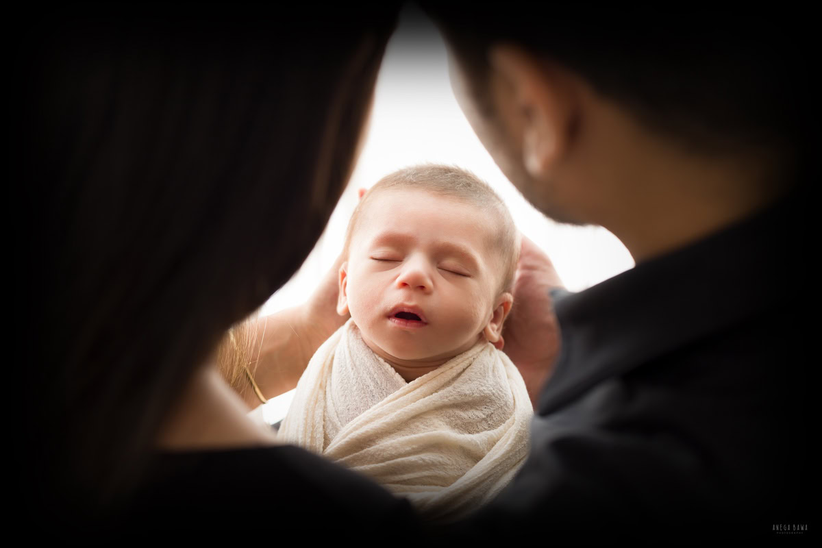 Newborn Photography in Delhi: Family captured in a cute pose by Anega Bawa Photography in Gurgaon.