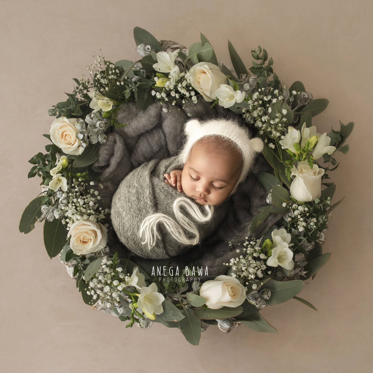 Newborn Photography in Delhi: Grey Wrap, Floral Basket, White Cap, Beige Backdrop, by Anega Bawa Photographer, Gurgaon Noida.