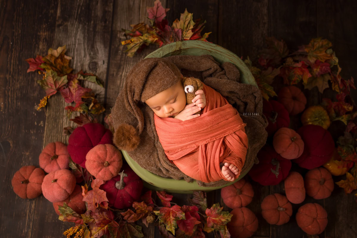 Newborn Photography in Delhi: Orange Wrap, Vegetable Green Basket, Brown Backdrop, by Anega Bawa Photographer, Gurgaon Noida.
