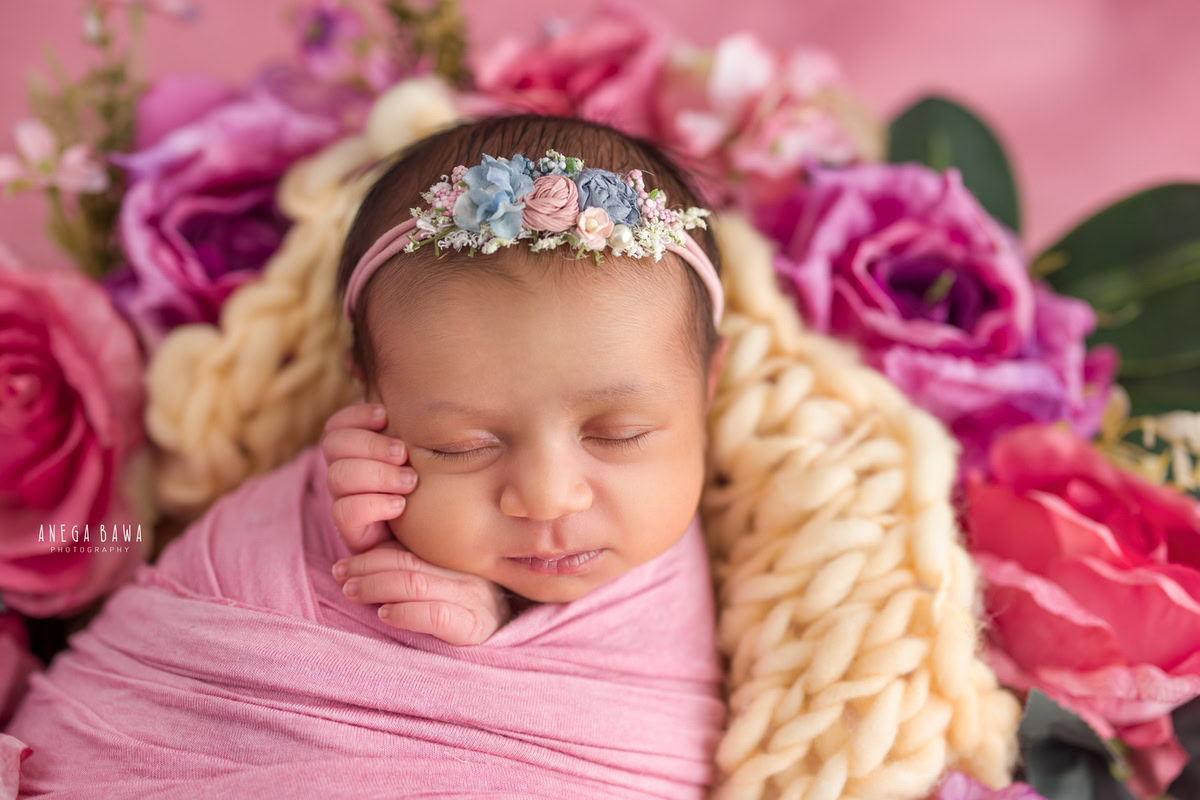 Newborn Photography in Delhi: Pink Wrap with Floral Basket on Pink Backdrop. Photographer: Anega Bawa, Gurgaon Noida.