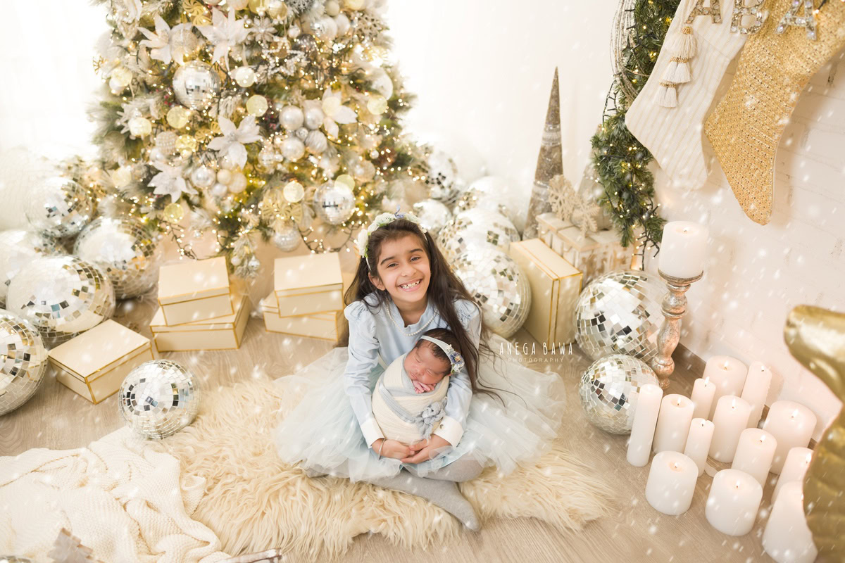 Newborn Photography in Delhi: Sibling in Beige and White Wrap with Discoball and Xmas Tree. Photographer: Anega Bawa, Gurgaon Noida.