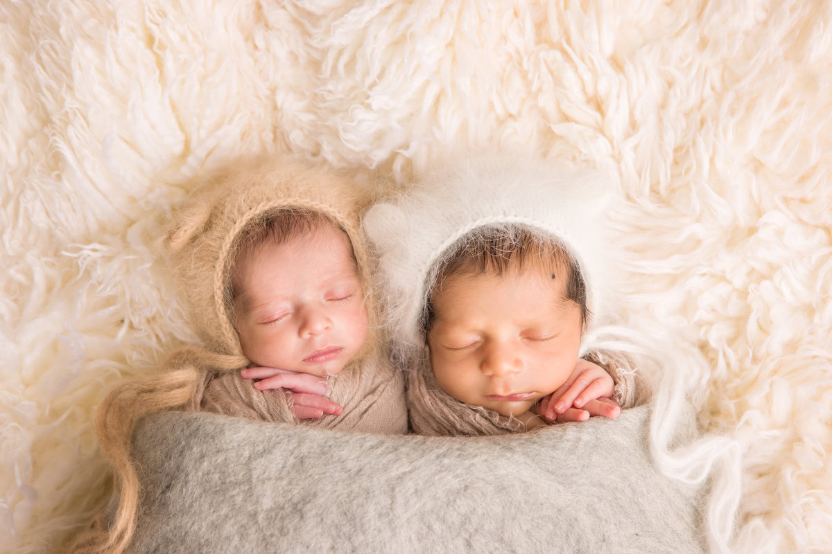 Newborn Photography in Delhi: Siblings wrapped in Brown, Lying on a Grey Blanket with a Beige Rug. Photographer: Anega Bawa, Gurgaon Noida.
