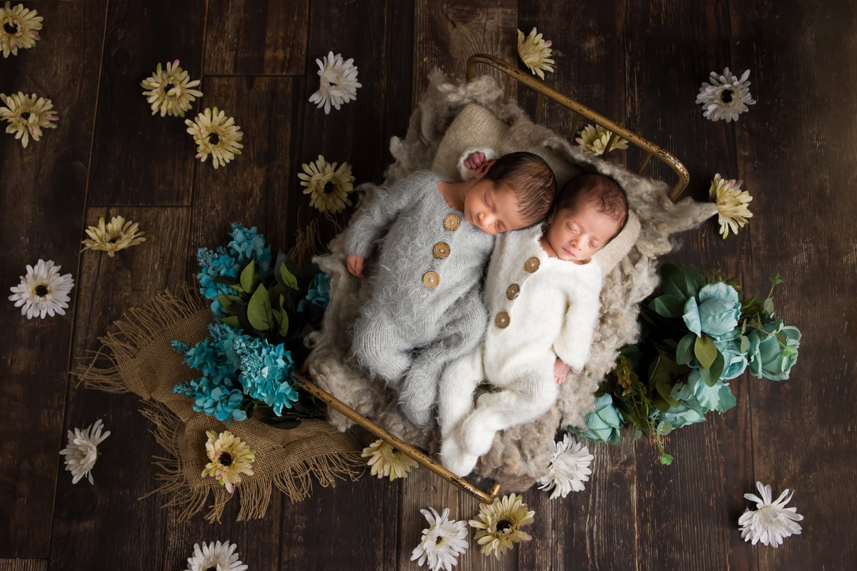 Newborn Photography in Delhi: Twins in Wooden Basket with Yellow and White Flowers on Wooden Backdrop, by Anega Bawa Photographer, Gurgaon Noida.