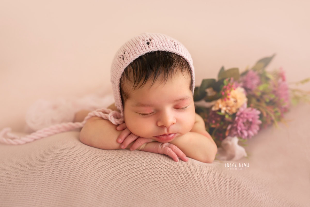 Newborn Photography in Delhi: White Cap with Flowers, Beige Backdrop. Photographer: Anega Bawa, Gurgaon Noida.