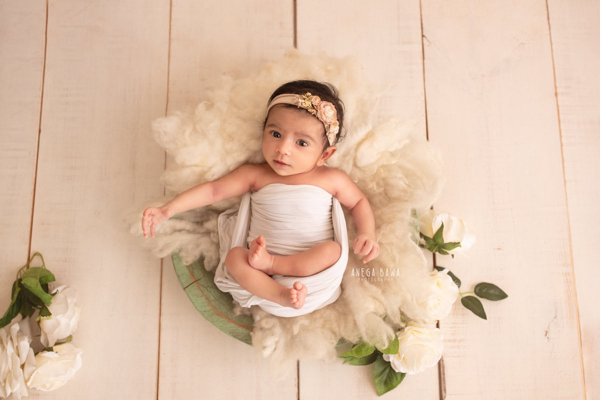 Newborn Photography in Delhi: White Wrap, Beige Headband, Beige Backdrop. Photographer: Anega Bawa, Gurgaon Noida.