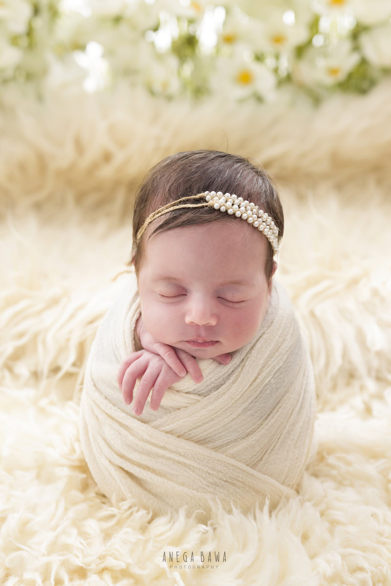 Newborn Photography in Delhi: White Wrap on Beige Rug with Pearl Headstring, by Anega Bawa Photographer, Gurgaon Noida.
