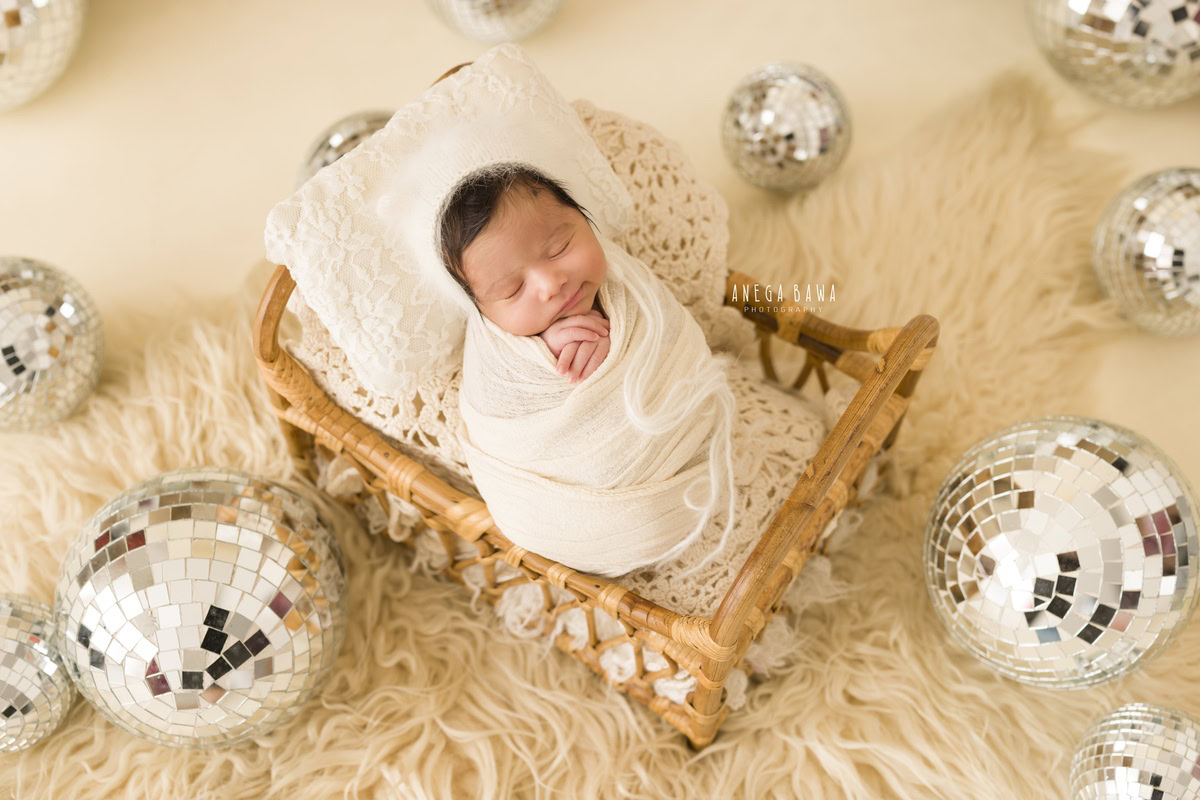 Newborn Photography in Delhi: White Wrap with Discoball, Beige Rug, by Anega Bawa Photographer, Gurgaon Noida.