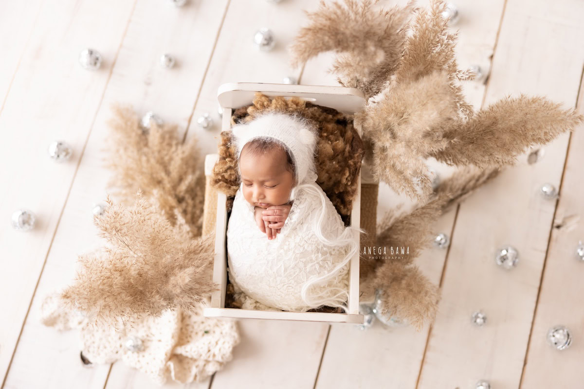 Newborn Photography in Delhi: White Wrap with Pampas and Silver Balls, White Cap. Photographer: Anega Bawa, Gurgaon Noida.