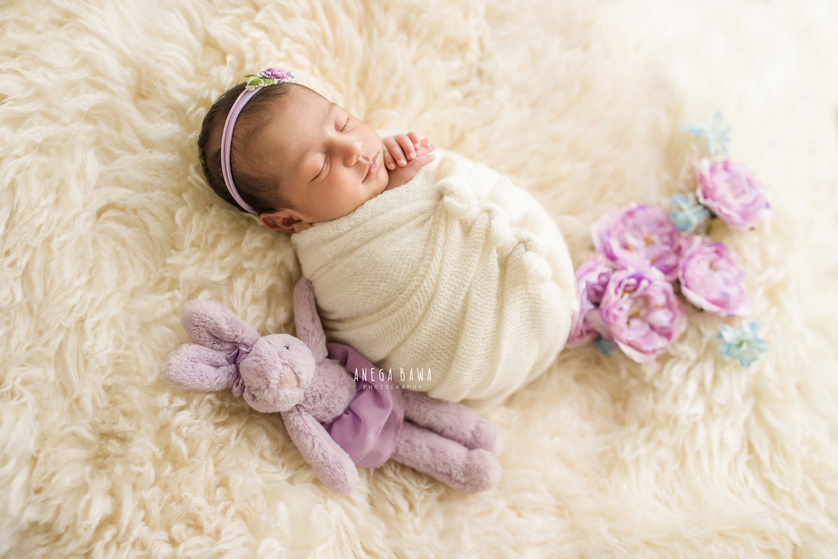 Newborn Photography in Delhi: White Wrap, Soft Toy, Flowers, White Rug. Photographer: Anega Bawa, Gurgaon Noida.
