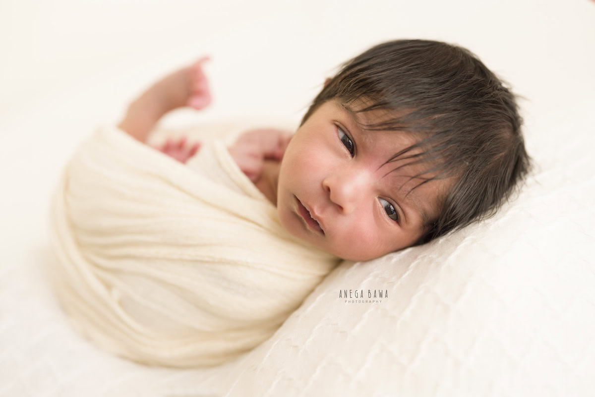Newborn Photography in Delhi: White Wrap against White Backdrop. Photographer: Anega Bawa, Gurgaon Noida.