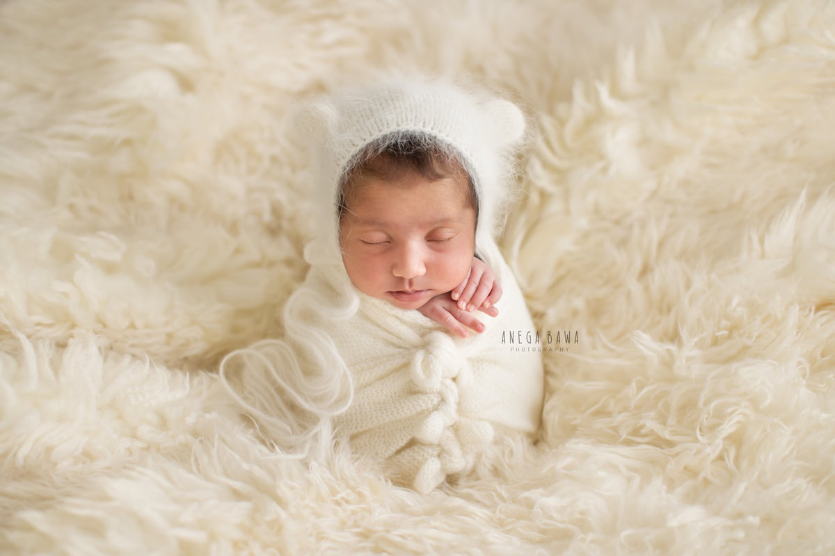 Newborn Photography in Delhi: White Wrap, White Cap, White Rug. Photographer: Anega Bawa, Gurgaon Noida.