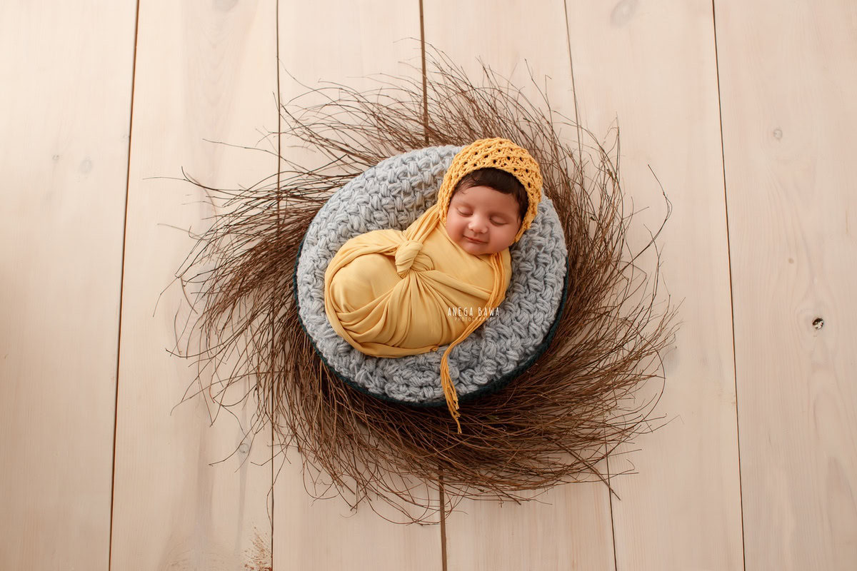 Newborn Photography in Delhi: Yellow Wrap, Beige Backdrop, Brown Bushes, by Anega Bawa Photographer, Gurgaon Noida.