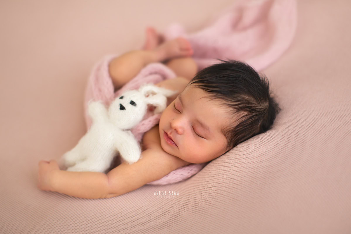 Newborn Photography at Home in Delhi: Sleeping Pose with Soft Toy, Beige Backdrop. Photographer: Anega Bawa, Gurgaon Noida.