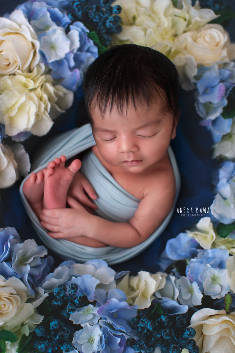 Newborn Photoshoot in Delhi: Blue Wrap with Blue and White Flowers, Sleeping Pose. Photographer: Anega Bawa Photography, Gurgaon Noida.