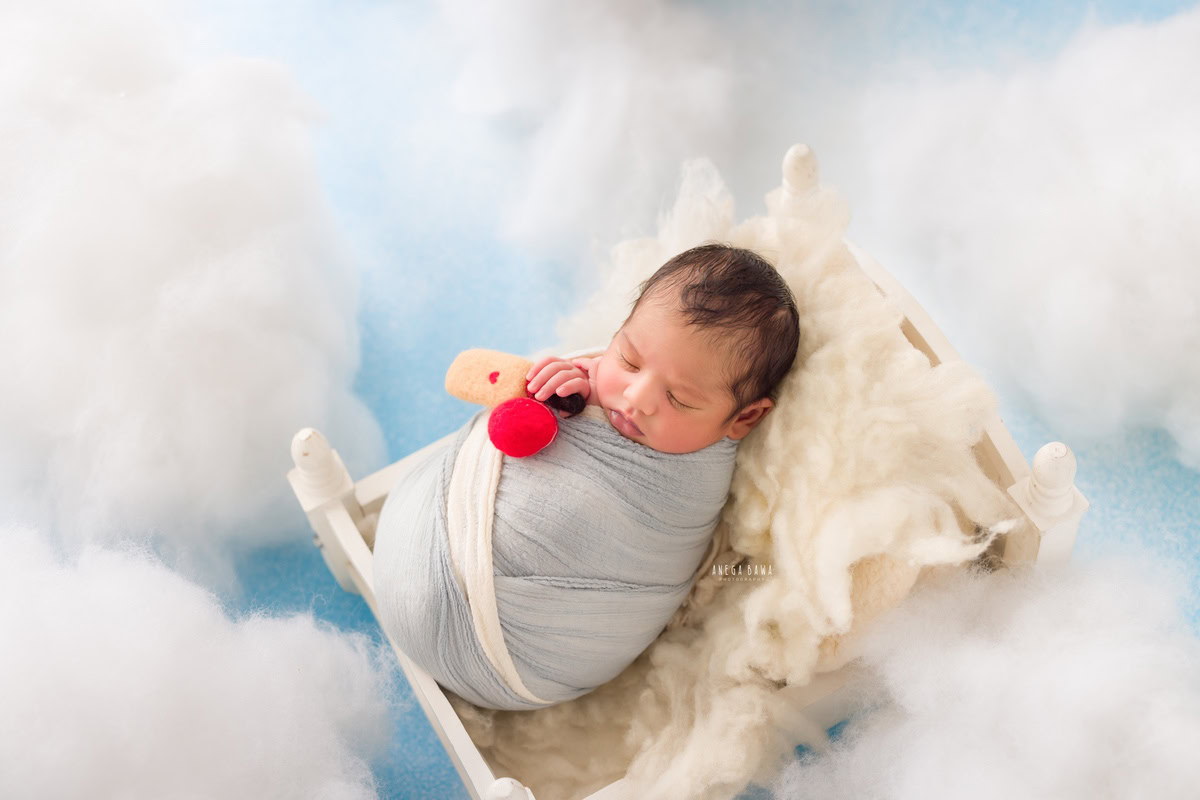 Newborn Photoshoot in Delhi: Blue Wrap with Clouds Backdrop. Photographer: Anega Bawa Photography, Gurgaon Noida.