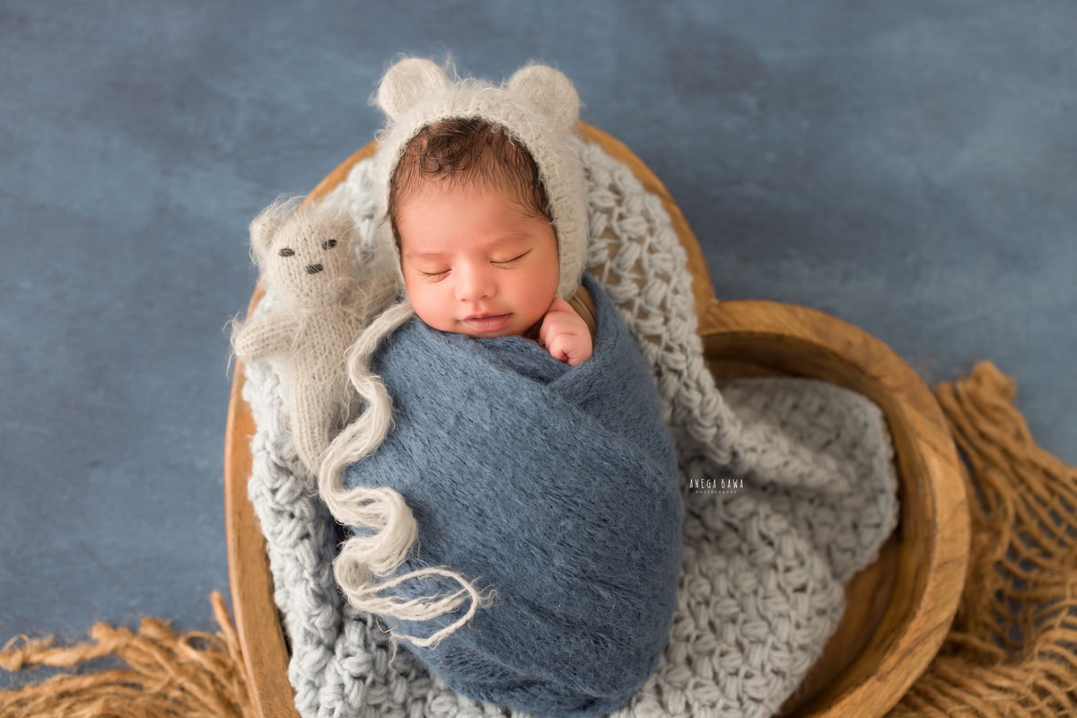 Newborn Photoshoot in Delhi: Blue Wrap, Grey Blanket, Floral Blue Basket, White Backdrop. Photographer: Anega Bawa Photography, Gurgaon Noida.