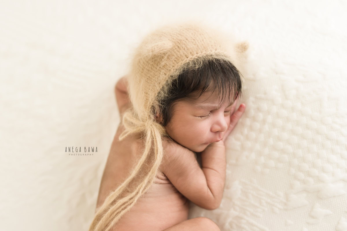 Newborn Photoshoot in Delhi: Brown Cap on White Backdrop. Photographer: Anega Bawa Photography, Gurgaon Noida.