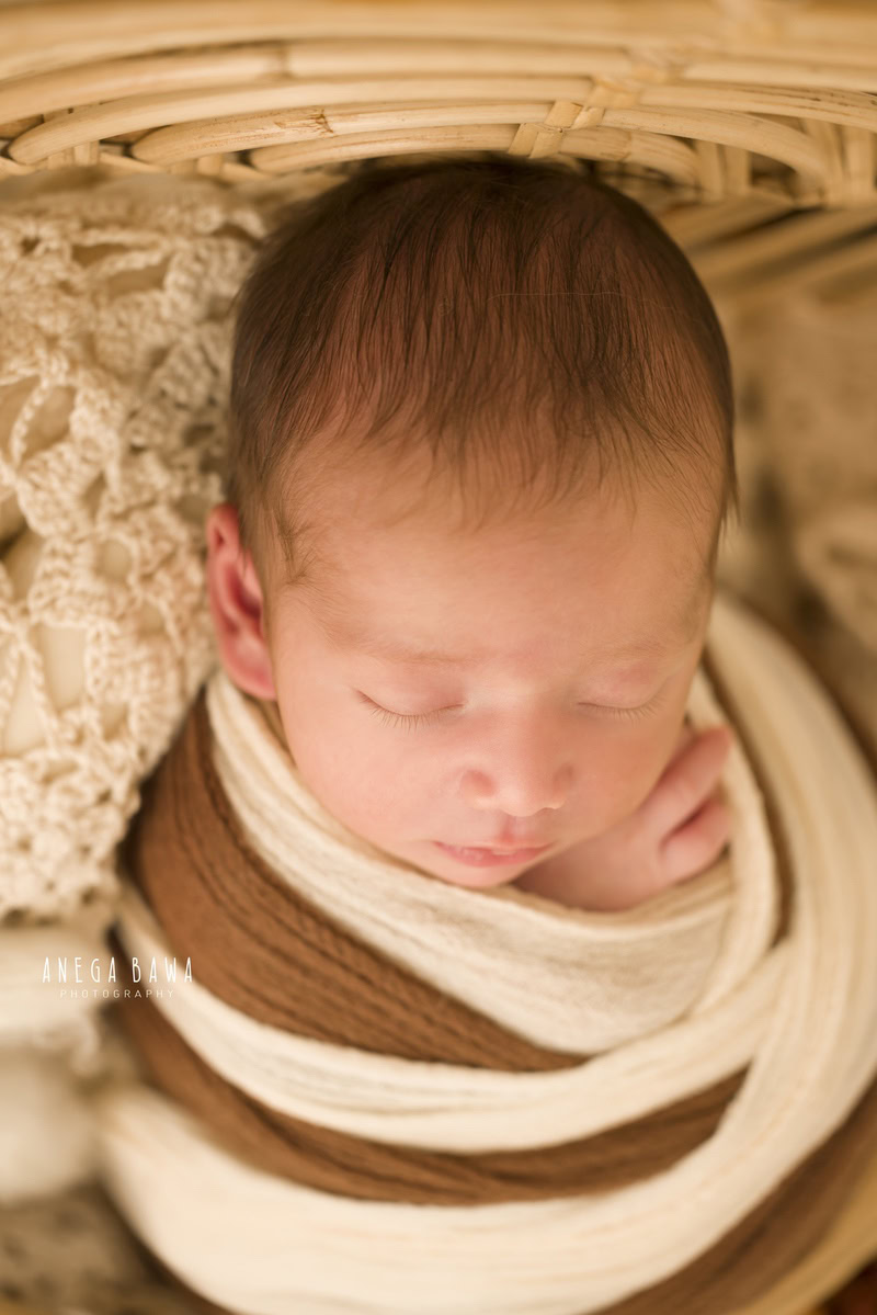 Newborn Photoshoot in Delhi: Brown and White Wrap, Capturing a Sleeping Pose. Photographer: Anega Bawa Photography, Gurgaon Noida.