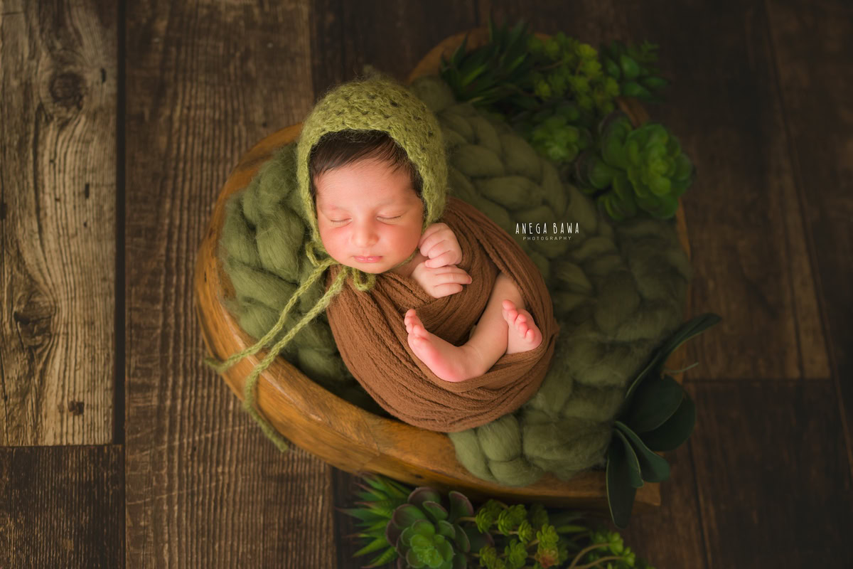Newborn Photoshoot in Delhi: Brown Wrap, Green Cap, Brown Backdrop. Photographer: Anega Bawa Photography, Gurgaon Noida.