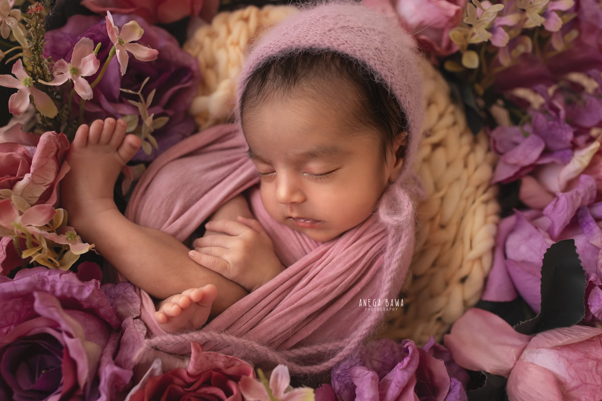 Newborn Photoshoot in Delhi: Pink Wrap with Floral Basket. Photographer: Anega Bawa Photography, Gurgaon Noida.