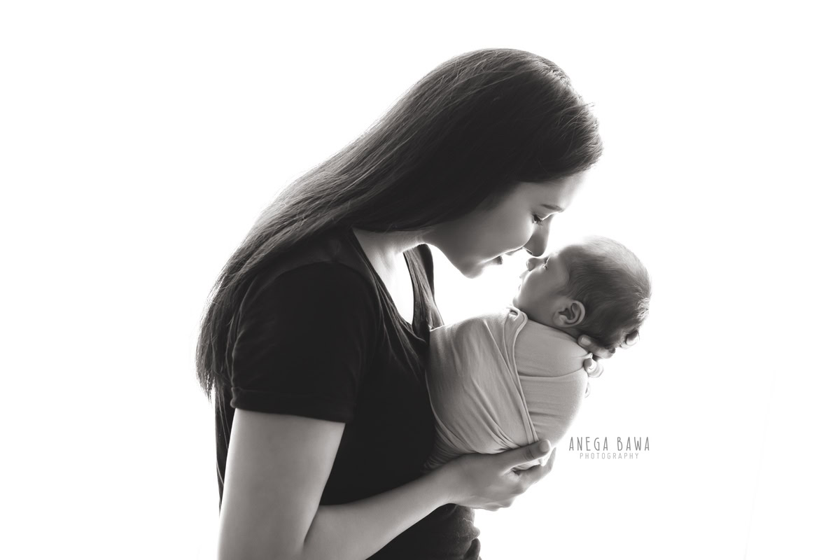 Newborn Photoshoot in Delhi: Mom with a white backdrop. Photographer: Anega Bawa Photography, Gurgaon.