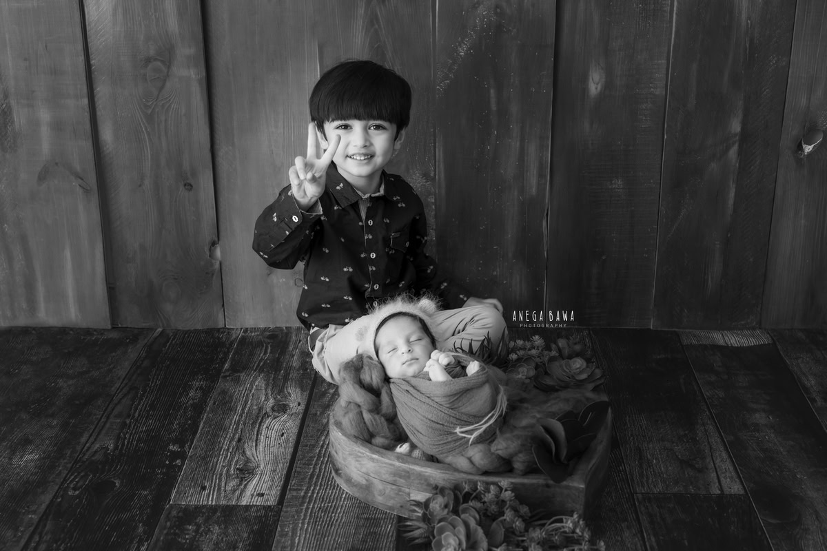 Newborn Photoshoot in Delhi: Sibling Photoshoot in Black and White. Photographer: Anega Bawa Photography, Gurgaon Noida.