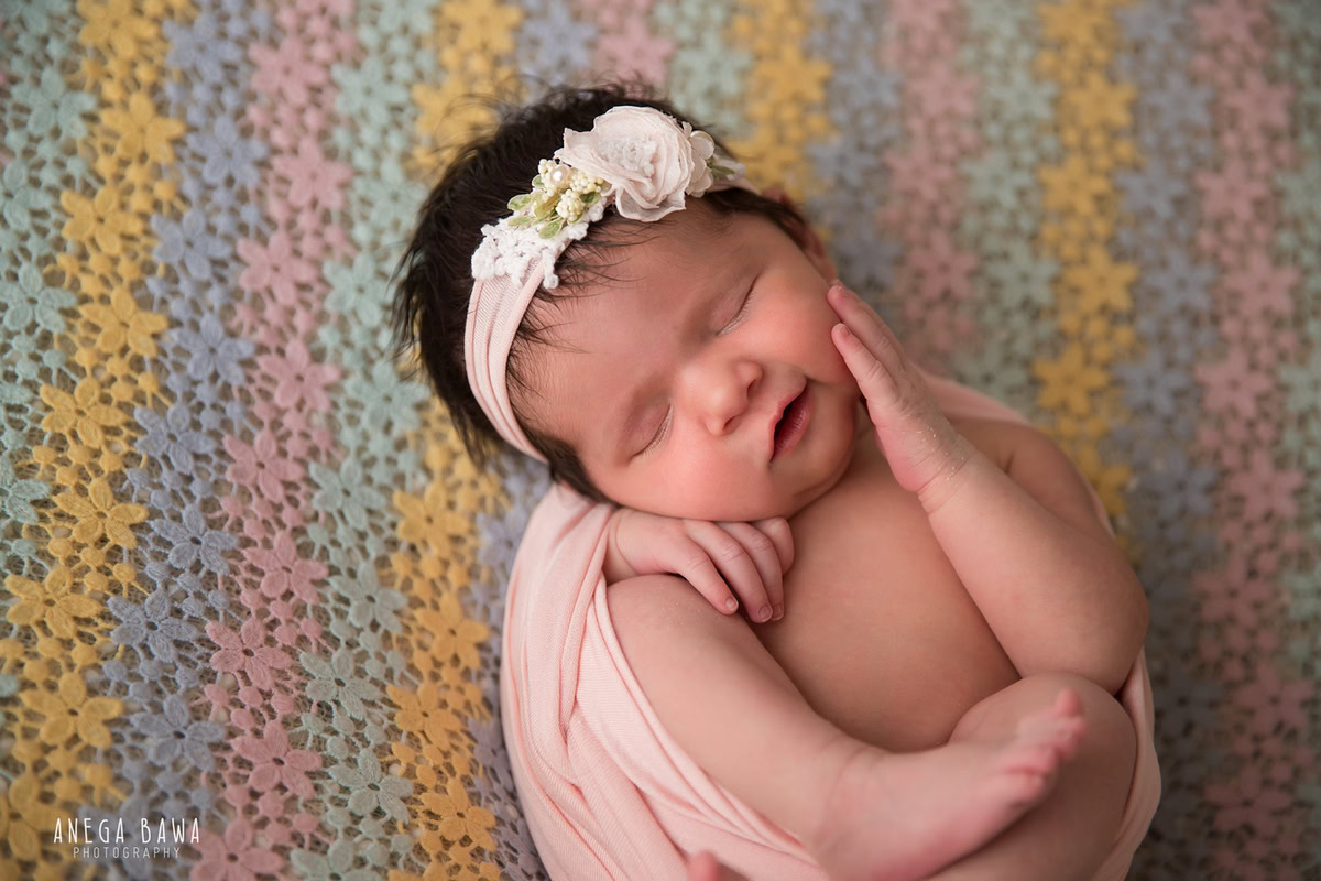 Newborn Photoshoot in Delhi: Adorable baby wrapped in pink with a cute headband. Photographer: Anega Bawa Photography, Gurgaon Noida.