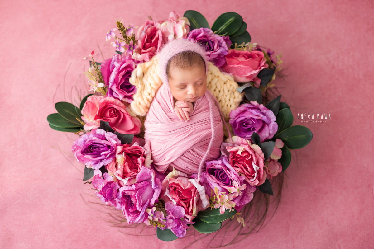 Newborn Photoshoot in Delhi: Pink Wrap with Floral Basket. Photographer: Anega Bawa Photography, Gurgaon Noida.