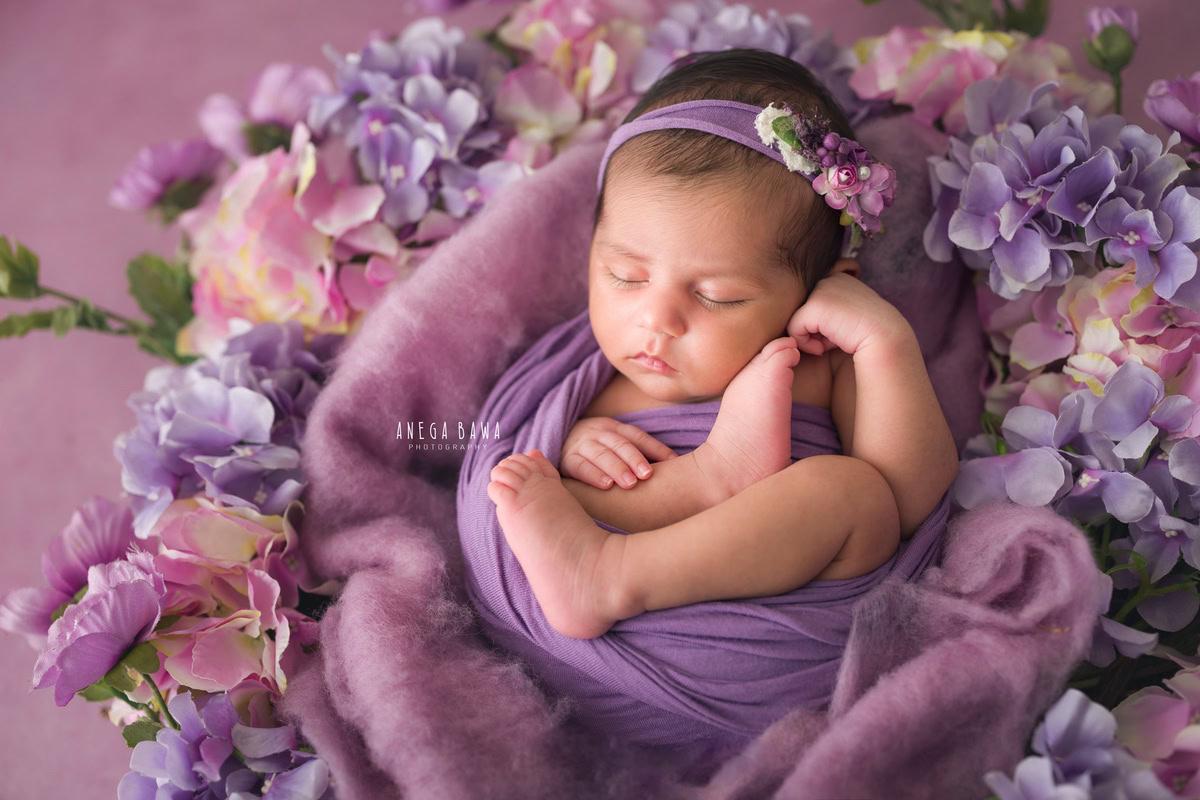 Newborn Photoshoot in Delhi: Purple Wrap with Multicolour Flowers, Purple Headband, Lavender Backdrop. Photographer: Anega Bawa Photography, Gurgaon Noida.