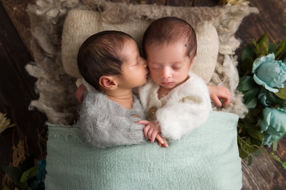 Newborn Photoshoot in Delhi: Twins dressed in grey and white baby suits against a brown backdrop. Photographer: Anega Bawa Photography, Gurgaon Noida.