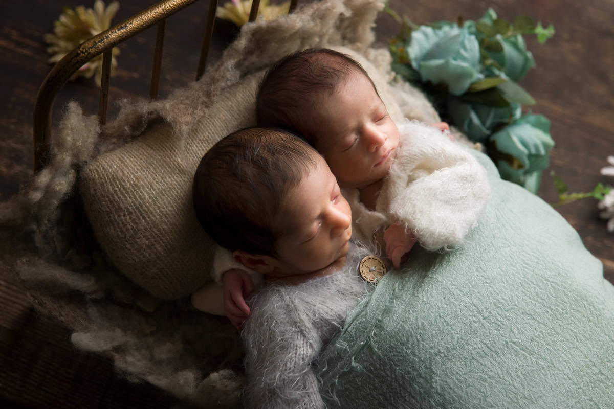 Newborn Photoshoot in Delhi: Twins captured in a peaceful sleeping pose against a brown backdrop. Photographer: Anega Bawa Photography, Gurgaon Noida.