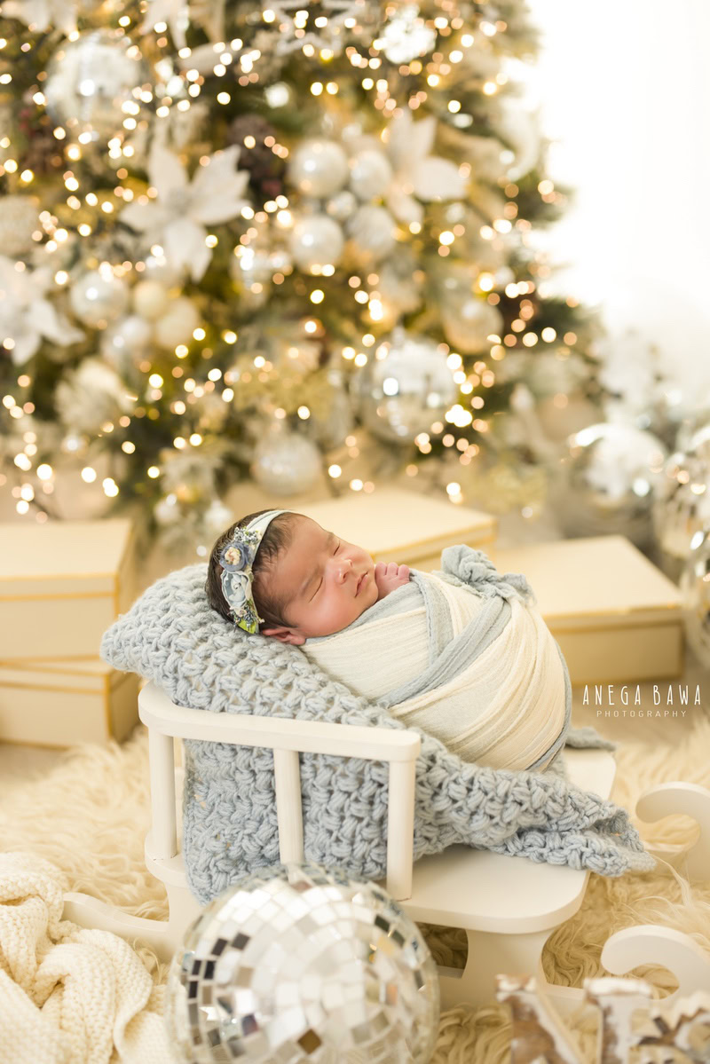 Newborn Photoshoot in Delhi: White Backdrop with Blue and White Wrap, featuring Xmas Theme. Photographer: Anega Bawa Photography, Gurgaon Noida.